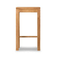 Front profile of a backless outdoor bar stool in natural teak, solid wood construction with a square seat, straight legs and a low footrest, styled for coastal outdoor use on a white background.