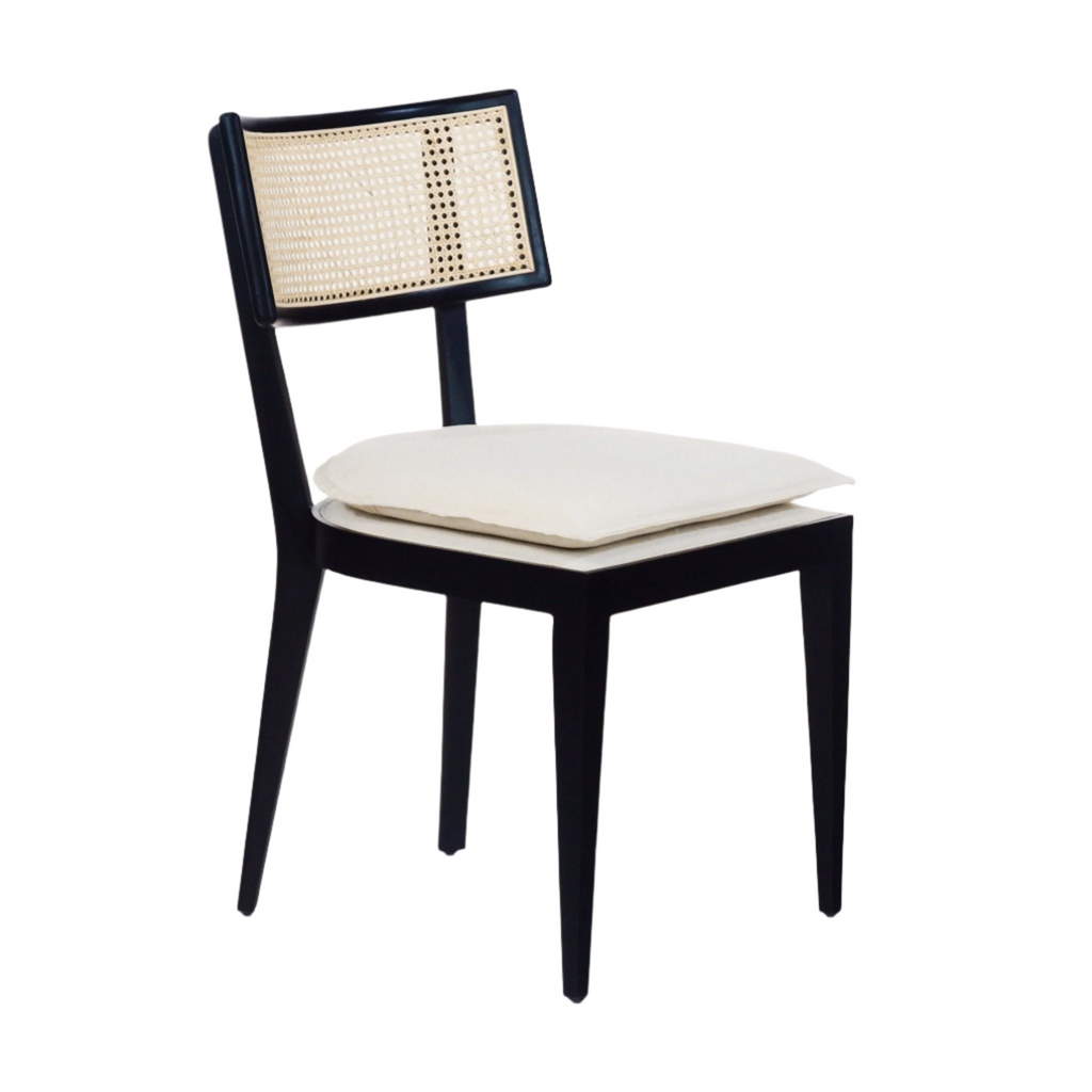 Black solid wood dining chair with a woven rattan backrest and cream upholstered seat cushion, armless mid-century modern silhouette with tapered legs.