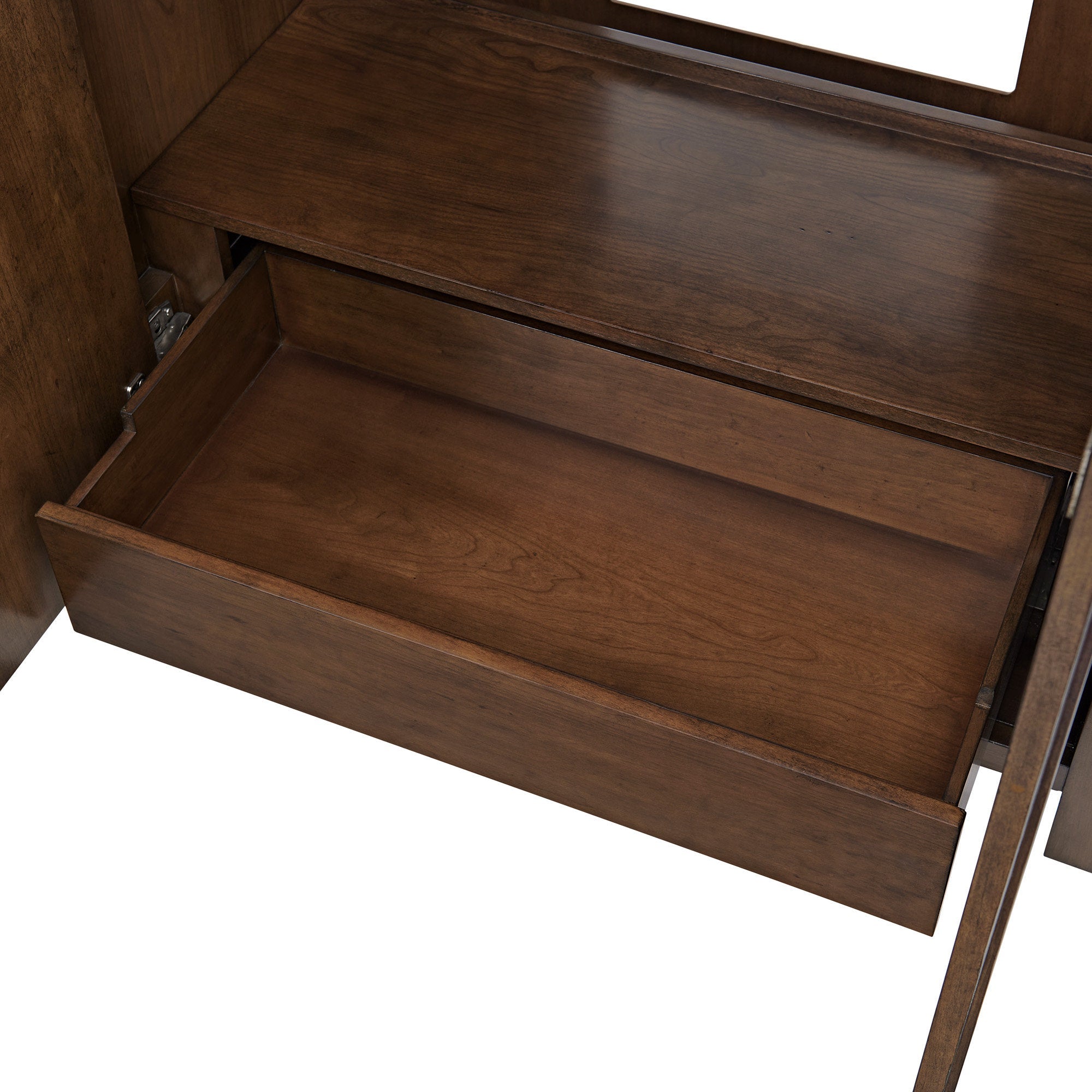 Close-up of an open solid wood vanity drawer showing warm brown wood grain interior, smooth finish and metal slides, highlighting the storage compartment inside a contemporary bathroom vanity.