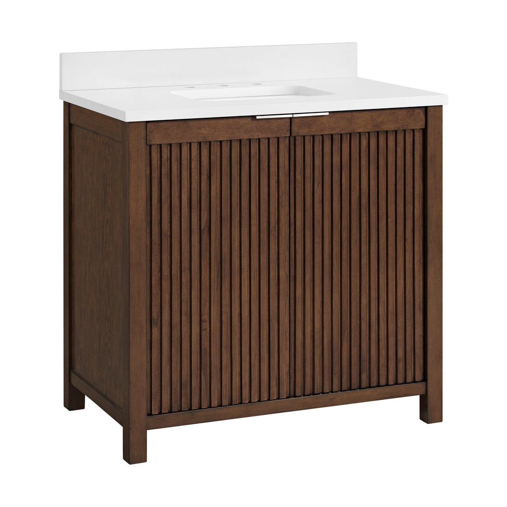 Freestanding solid wood single-sink bathroom vanity in warm brown with vertical fluted cabinet doors, white stone countertop with integrated rectangular sink, slim metal drawer pull and low backsplash.