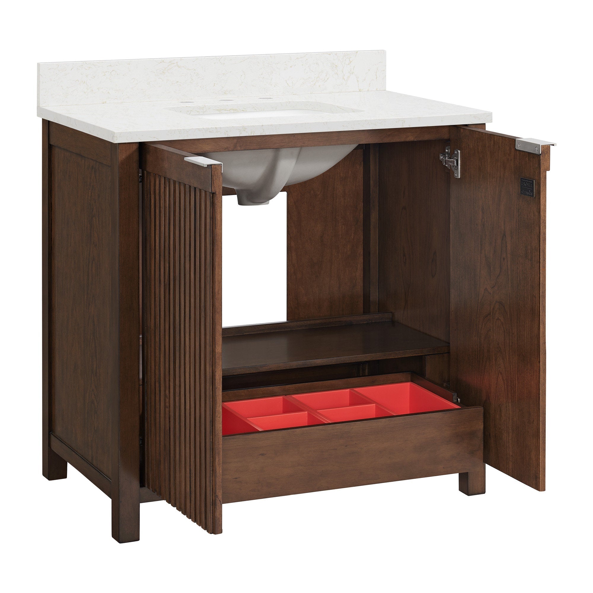 Modern solid-wood single-sink bathroom vanity with a white stone countertop and backsplash; brown fluted cabinet doors opened to reveal an interior shelf, a lower drawer with a red storage organizer, and the ceramic sink basin.