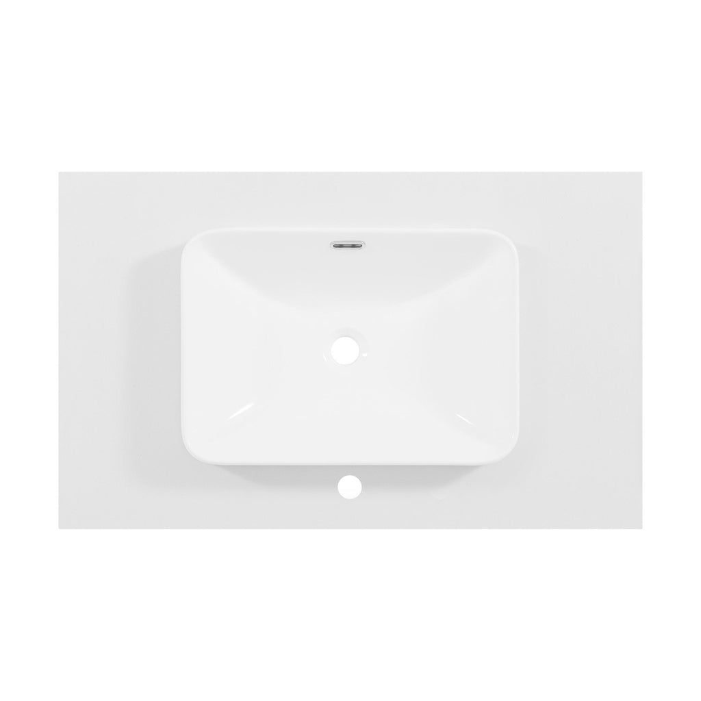 Overhead view of a white rectangular ceramic sink recessed into a stone-colored vanity top, showing the centered drain, overflow slot and single faucet hole for a modern bathroom vanity.