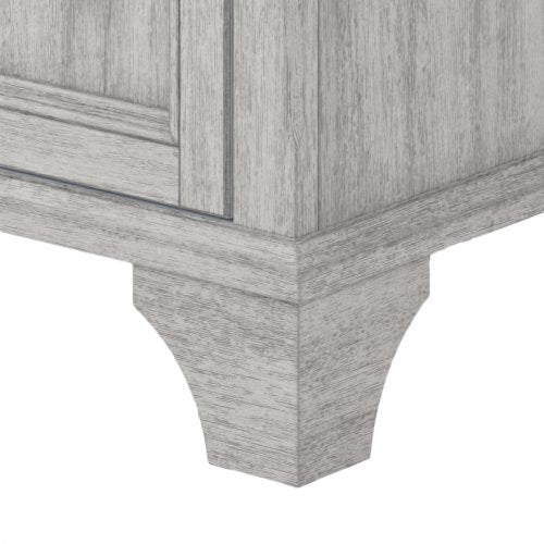 Close-up of a stone-colored solid wood vanity corner showing the molded base, tapered leg and visible wood grain on contemporary modern cabinetry.
