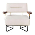 Off-white fabric upholstered low lounge chair with a rectangular padded back and wide cushioned seat, brown wooden arm pads on brass-accented metal supports, and a black metal sled-style base.