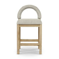 Front view of a counter stool with taupe boucle upholstered arched back and padded seat on a natural oak frame with double stretchers and subtle turned leg details.