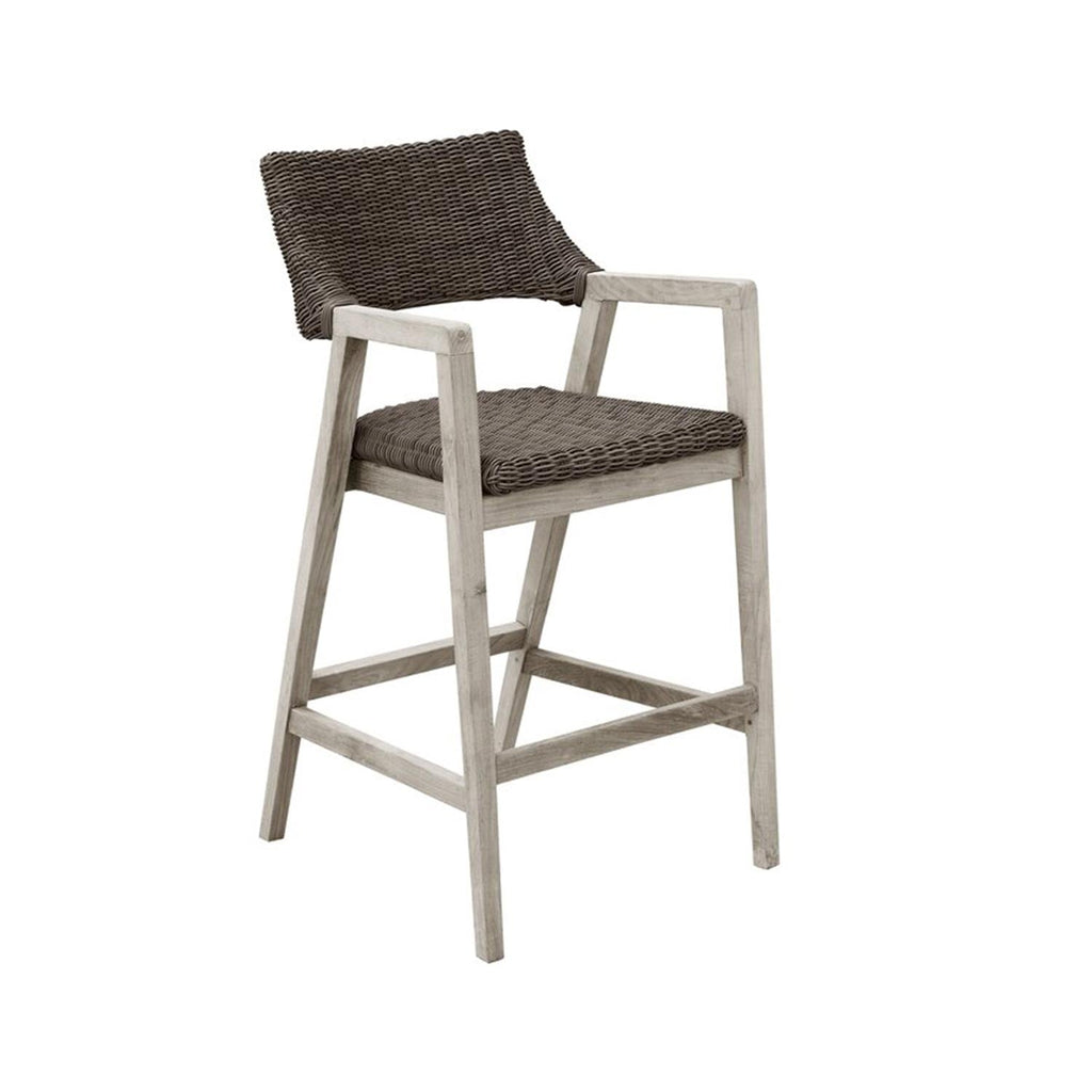 Teak outdoor bar stool with weathered natural finish and gray-brown woven rope seat and backrest, angled legs and integrated armrests shown on a white background.