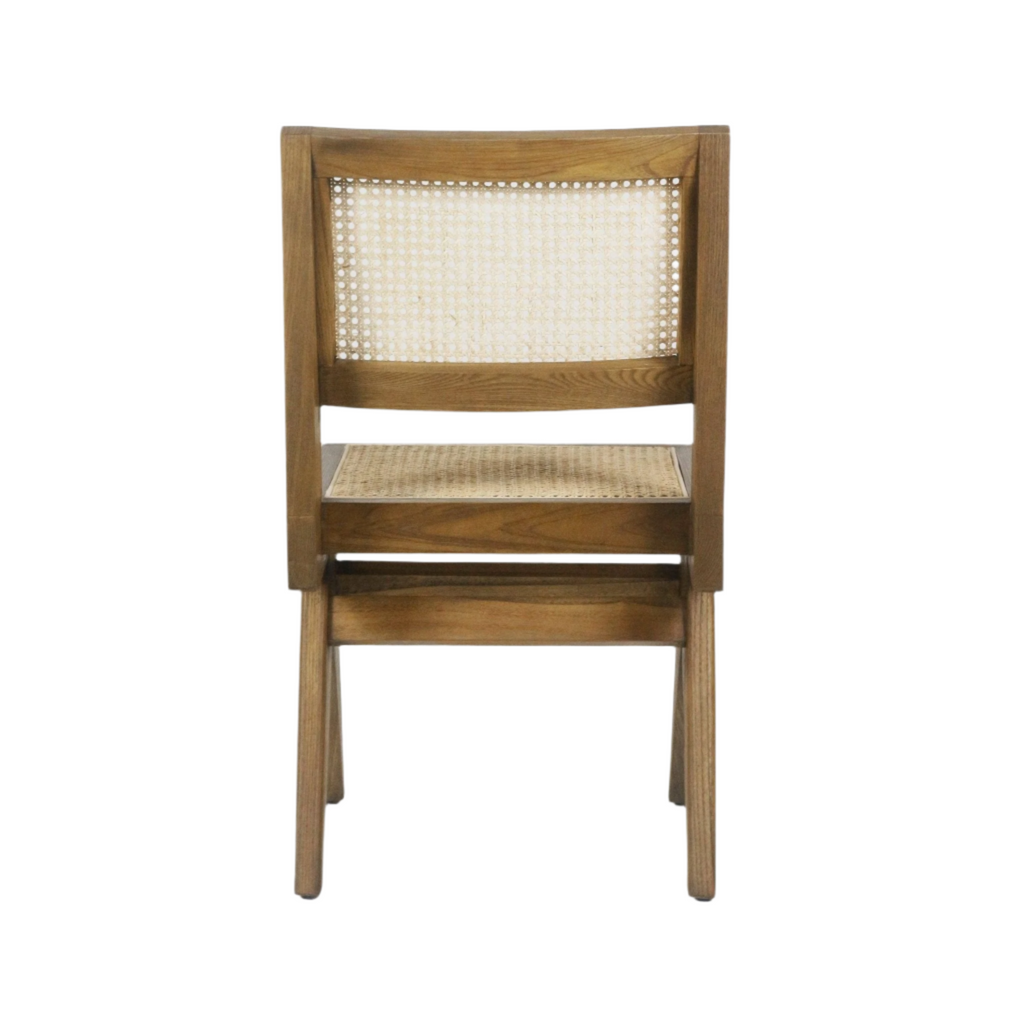 Rear view of an armless dining side chair with a natural wood frame in warm teak finish, woven cane seat and back, tapered legs and a clean mid-century modern silhouette.