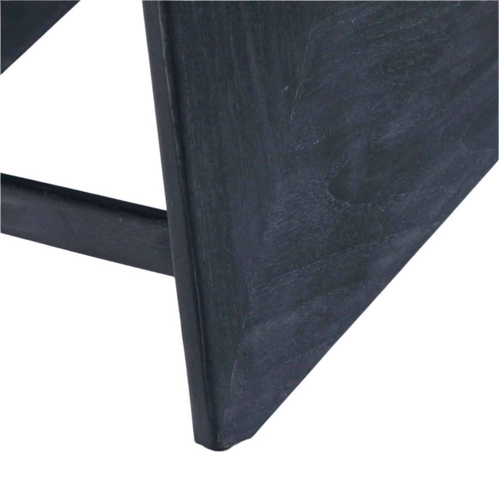 Close-up of a smoked black teak chair leg and stretcher showing the tapered triangular end, visible wood grain and matte solid-wood finish.