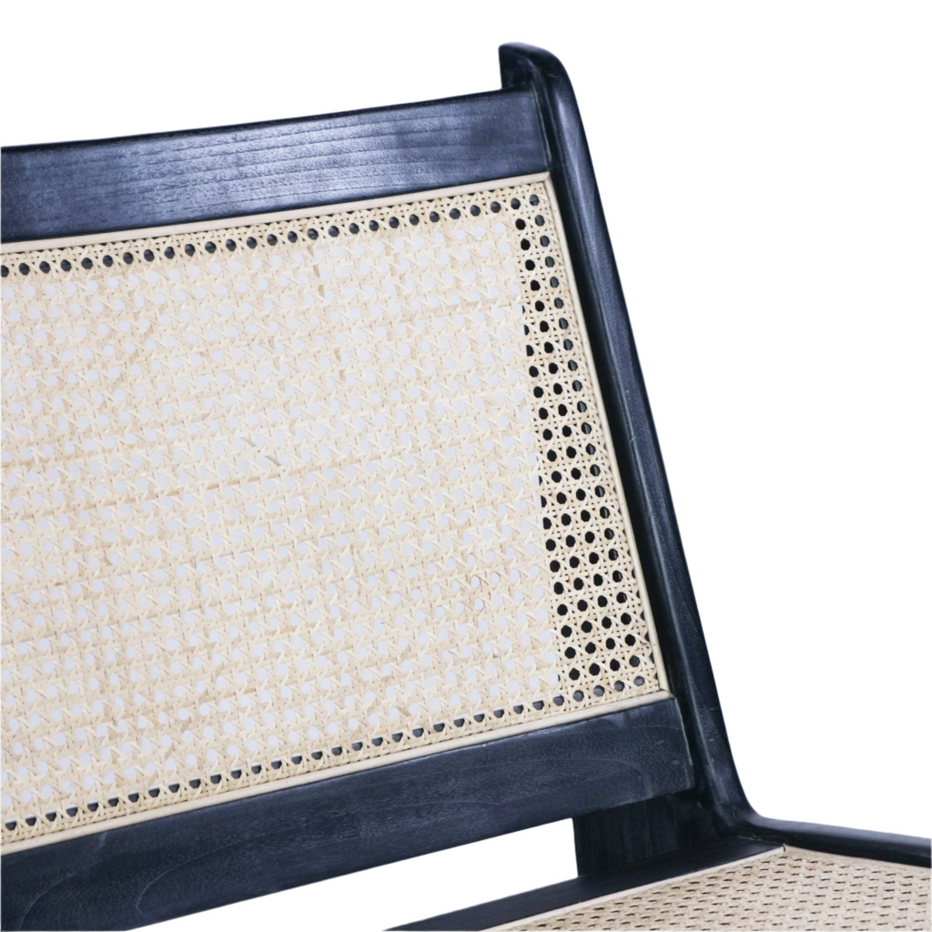 Close-up of a natural woven cane back and seat set in a black-stained teak wood frame, highlighting the handwoven cane pattern and rounded top rail.
