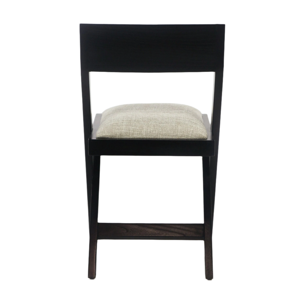 Front view of an armless mid-century modern black wood side chair with an open rectangular back and a beige upholstered seat cushion.