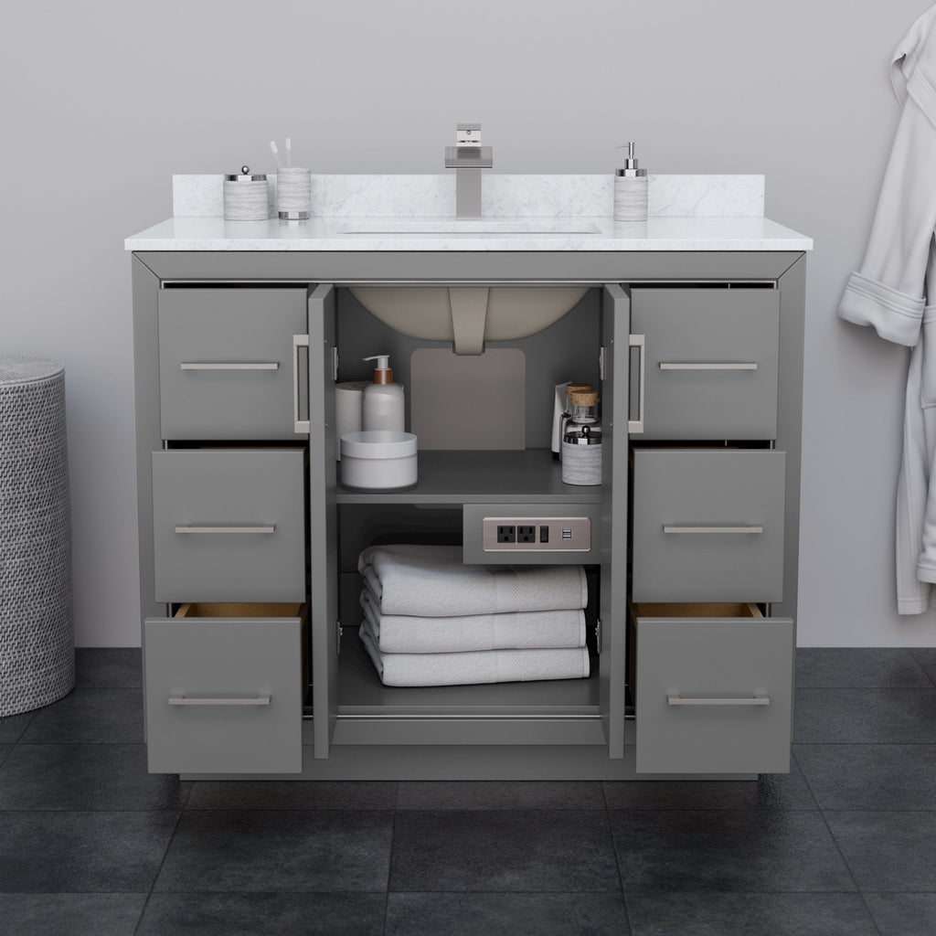 Modern 42-inch solid wood bathroom vanity in stone-gray finish with white stone countertop and integrated rectangular sink, six drawers and open center cabinet showing folded towels, toiletries and a built-in power outlet.