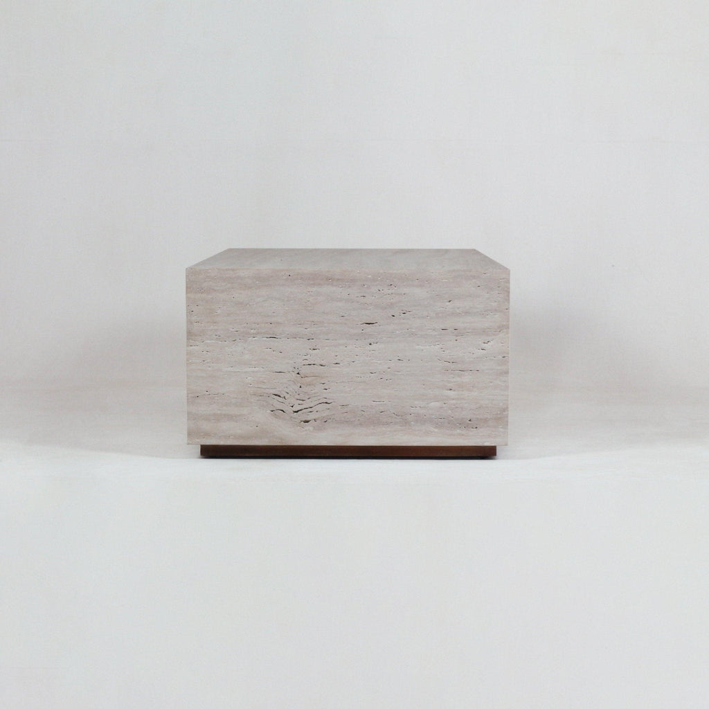 Minimalist rectangular coffee table in natural beige travertine with horizontal veining, sitting on a slim wooden base against a plain white studio background.