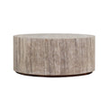 Round drum-style coffee table crafted from natural travertine marble in beige tones, showing vertical stone veining and a thin dark low base for a modern contemporary living room.