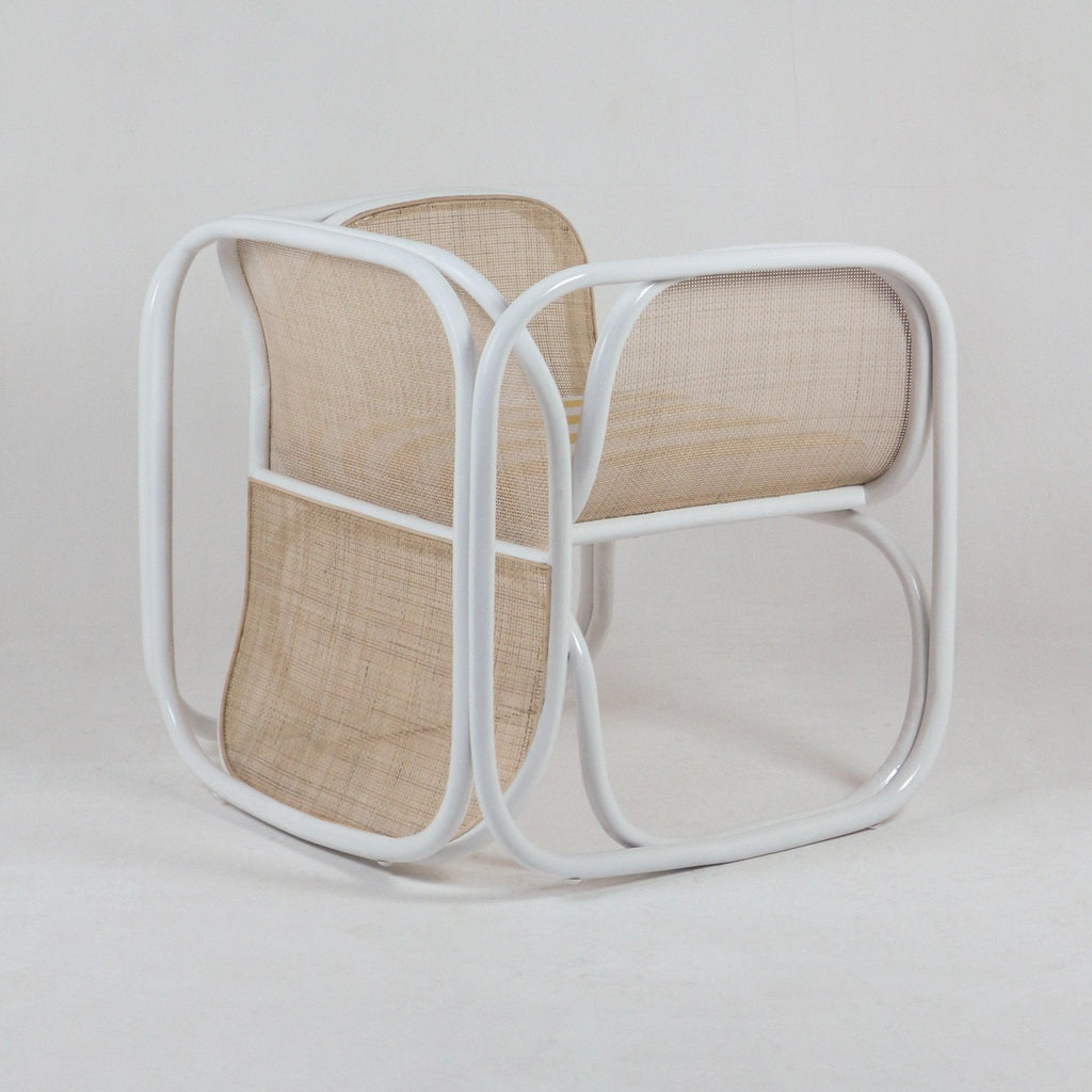 Modern lounge chair with curved white tubular metal frame and natural woven cane seat and back, low-profile contemporary silhouette suitable for living rooms.