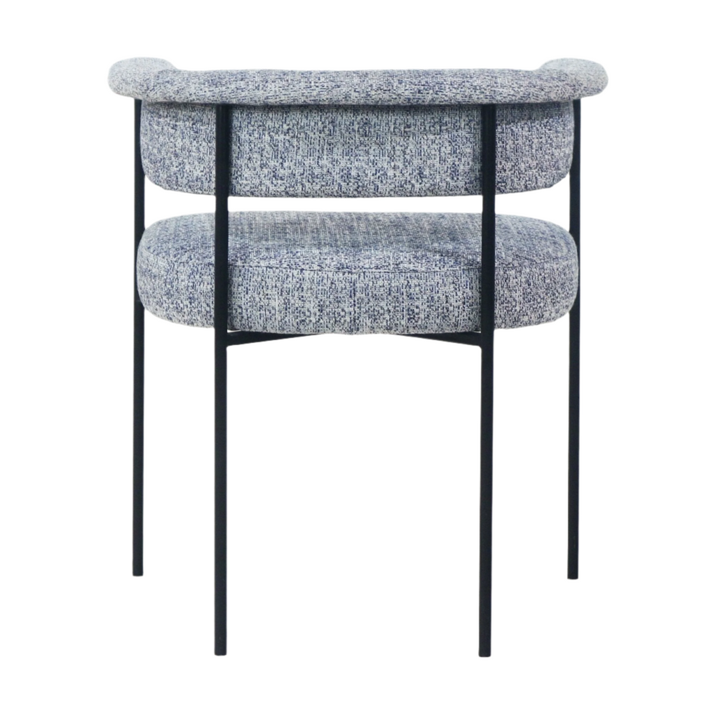 Rear view of a modern dining chair upholstered in textured gray bouclé with rounded back and seat cushions, supported by a slender black metal frame and legs.
