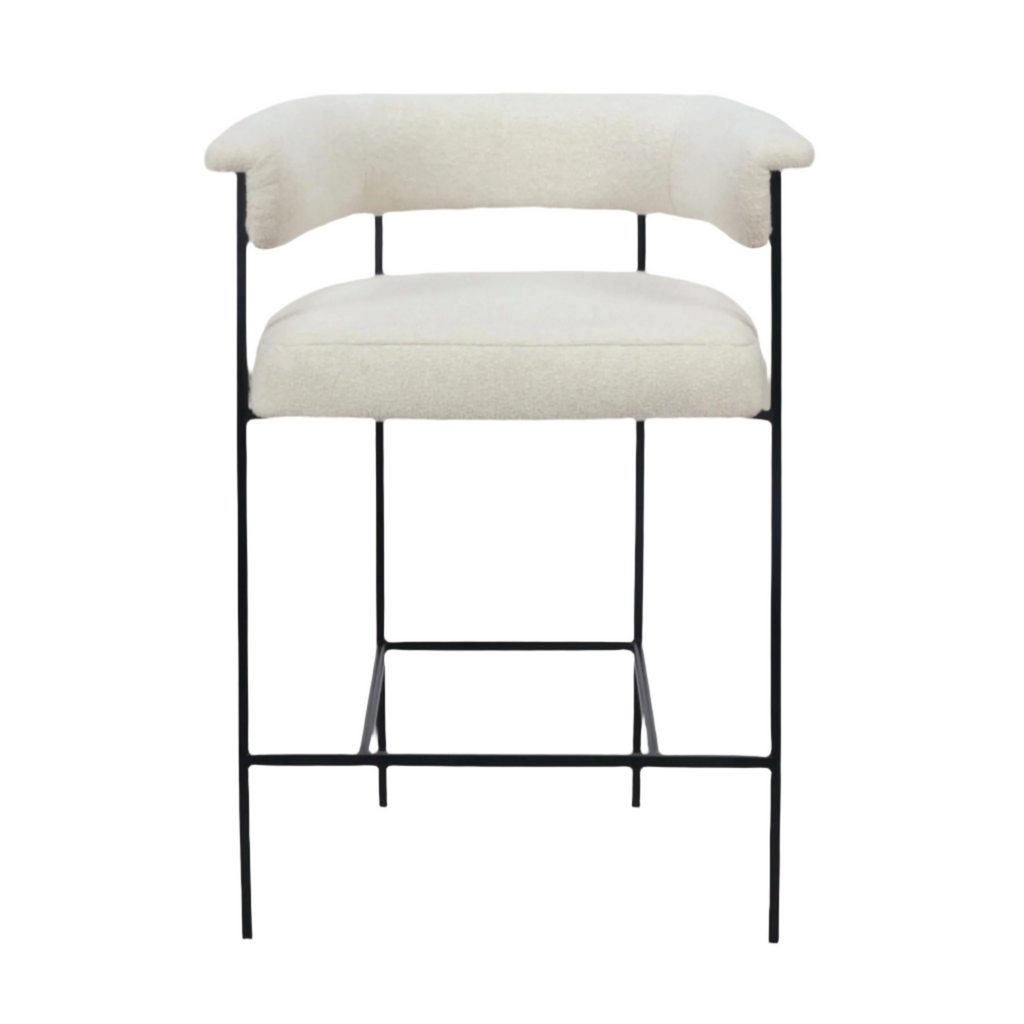 Cream boucle-upholstered counter stool with a rounded low back, cushioned seat and slender black metal frame with integrated footrest in a modern minimalist style.