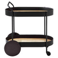 Modern two-tier bar cart with a matte black metal frame, woven rattan cane shelves, integrated handle, oversized round wooden rear wheels and a front caster for easy rolling.
