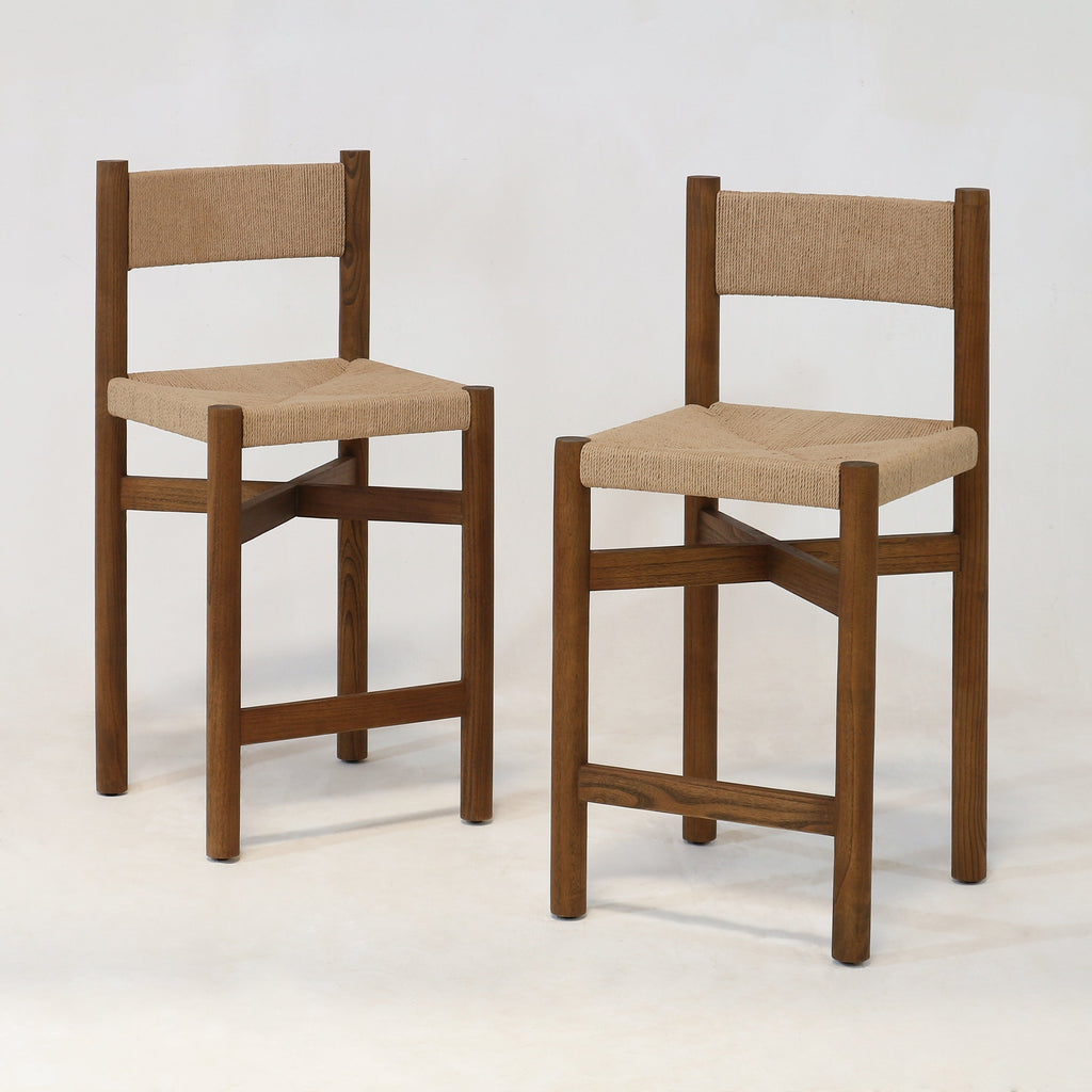 Two walnut-brown solid wood counter stools with woven natural papercord seat and back, armless square-leg frames with cross stretchers shown on a plain white background.