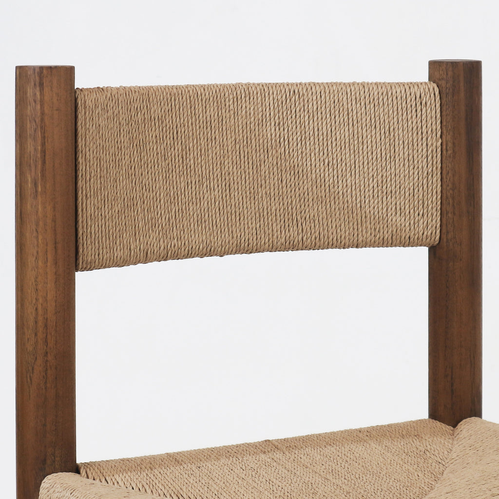 Close-up of a natural papercord woven back and seat attached to a walnut-stained solid wood frame with rounded vertical posts.