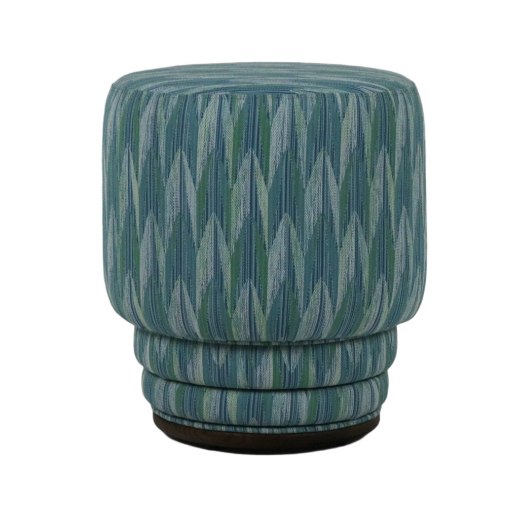 Modern round ottoman upholstered in teal and green chevron-patterned performance fabric, featuring stacked ring cushioning and a low dark wooden base.