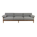 Three-seat outdoor sofa with a natural teak wood frame and gray Sunbrella fabric cushions, low-profile coastal-modern silhouette with padded armrests and raised legs.