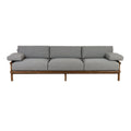 Three-seat outdoor sofa with a natural teak wood frame and gray Sunbrella fabric cushions, low-profile coastal-modern silhouette with padded armrests and raised legs.