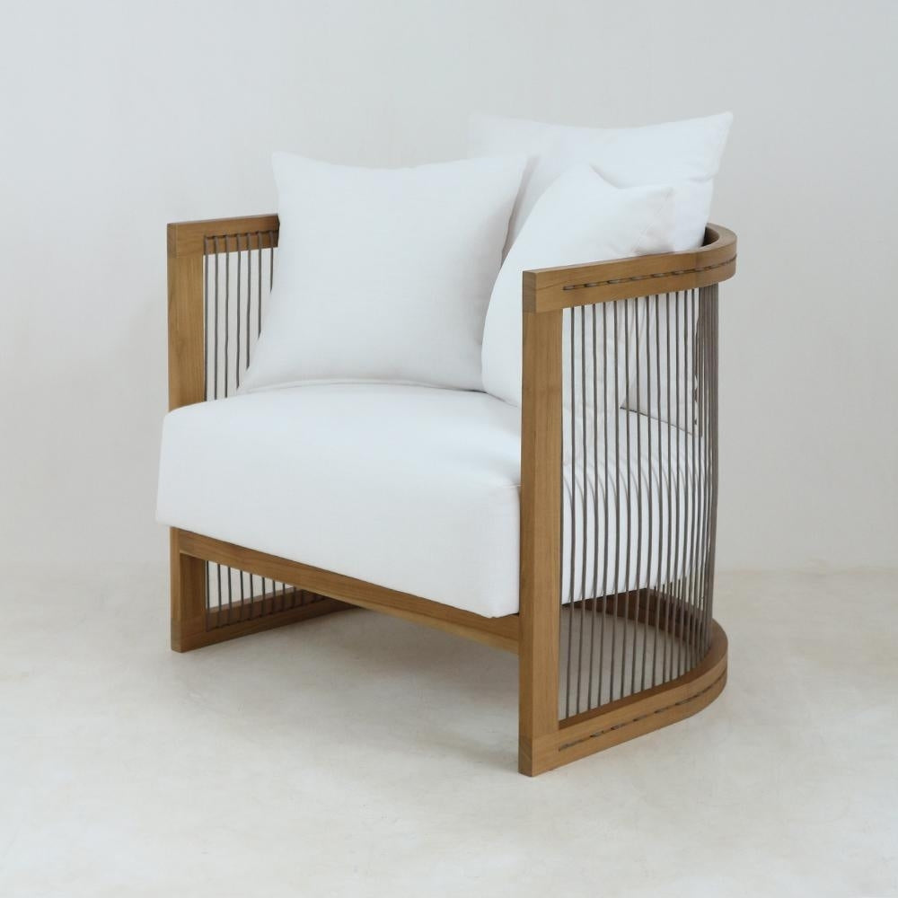 Modern lounge chair with white upholstered seat and three white cushions in a natural solid wood frame, featuring curved open sides with vertical woven rope/cord detailing for a minimalist look.