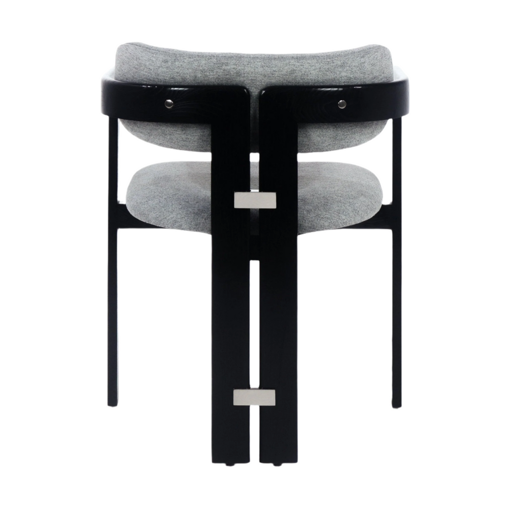 Rear view of a modern dining chair with grey boucle upholstered seat and curved back, black stained wood frame with two vertical slats, stainless rectangular hardware accents, and slim black legs.
