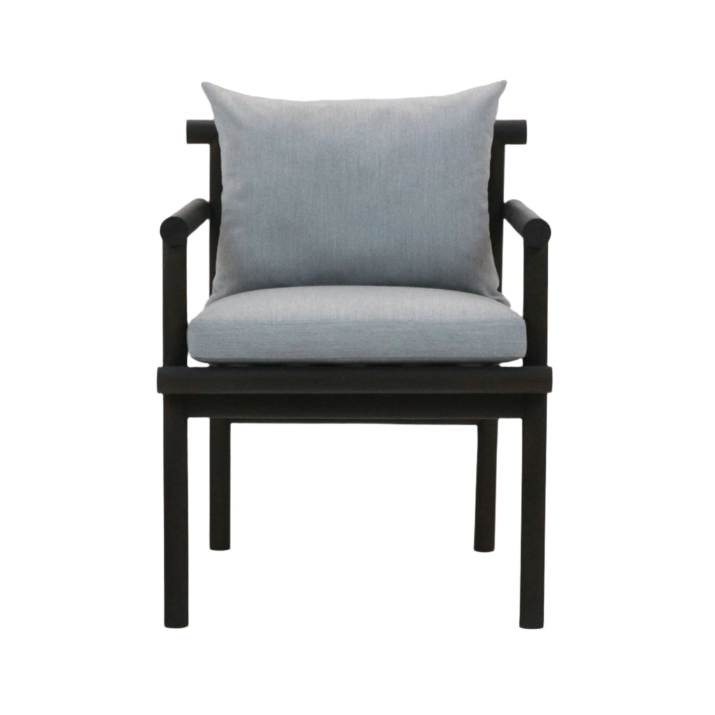 Front view of a patio armchair with a black teak wood frame and light gray Sunbrella fabric seat and back cushions, straight arms and square legs.