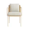 Coastal-style patio dining chair with a white aluminum frame, woven cane back and cream fabric upholstery with pale blue vertical stripes, padded seat and back cushions and rounded armrests.