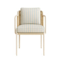 Coastal-style patio dining chair with a white aluminum frame, woven cane back and cream fabric upholstery with pale blue vertical stripes, padded seat and back cushions and rounded armrests.
