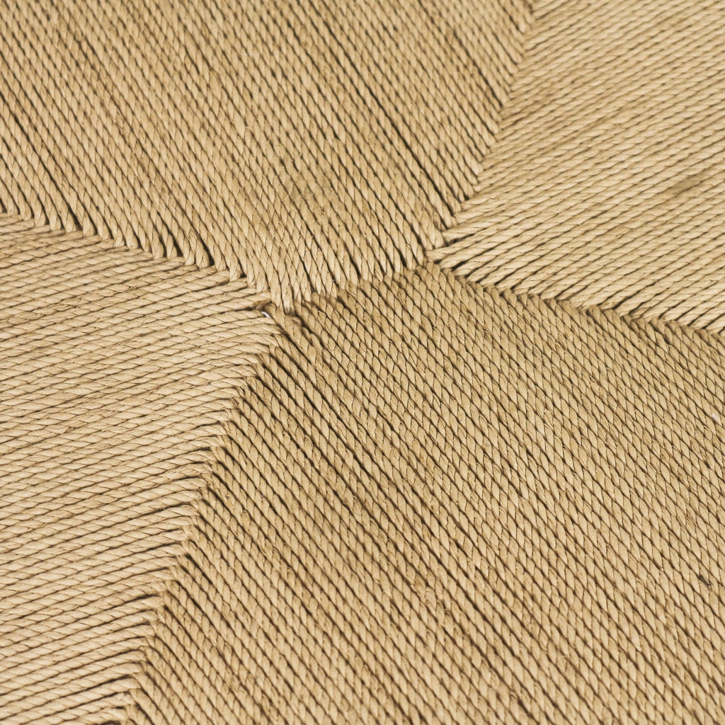 Close-up of a natural seagrass woven dining chair seat showing a square pattern of tightly twisted beige rope fibers and pronounced handwoven texture.