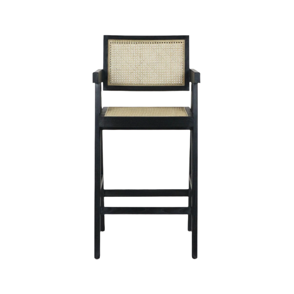 Black-stained wood bar stool with natural rattan cane seat and inset cane back, short armrests and integrated footrest in a mid-century modern silhouette.