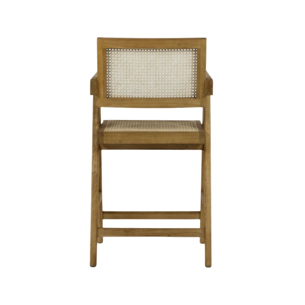 Front view of a natural wood counter stool with woven rattan seat and cane back, slim straight legs and short armrests in a mid-century modern style.