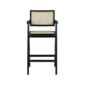 Black-stained wood bar stool with natural rattan cane seat and inset cane back, short armrests and integrated footrest in a mid-century modern silhouette.