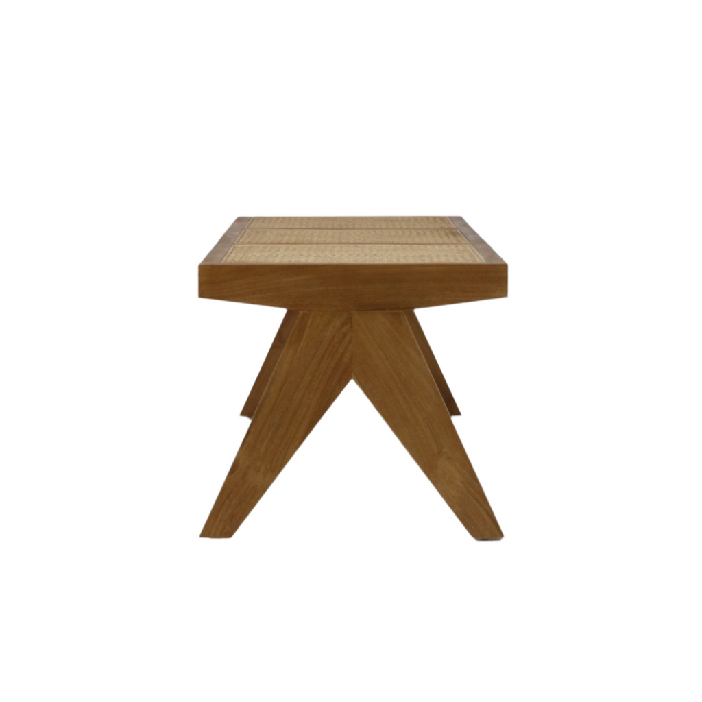Front view of a natural solid wood bench with a woven cane seat and sculptural angled V-shaped legs in a mid-century modern style, shown on a white background.
