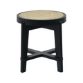Round accent stool with a natural woven cane inset seat set into a black solid wood frame, featuring splayed legs and an X-shaped cross-stretcher base in a mid-century modern style.