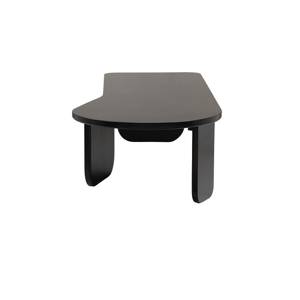 Front-facing photo of a modern black solid wood coffee table with an asymmetrical rounded top, curved legs and a recessed center tray on a white background.