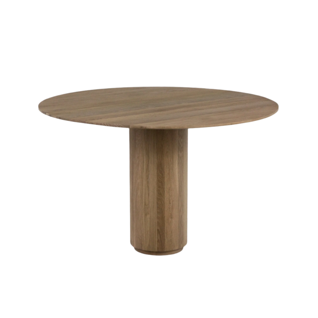 Round teak dining table in a natural wood finish with visible grain, featuring a single cylindrical pedestal base and clean mid-century modern lines suitable for dining or kitchen use.