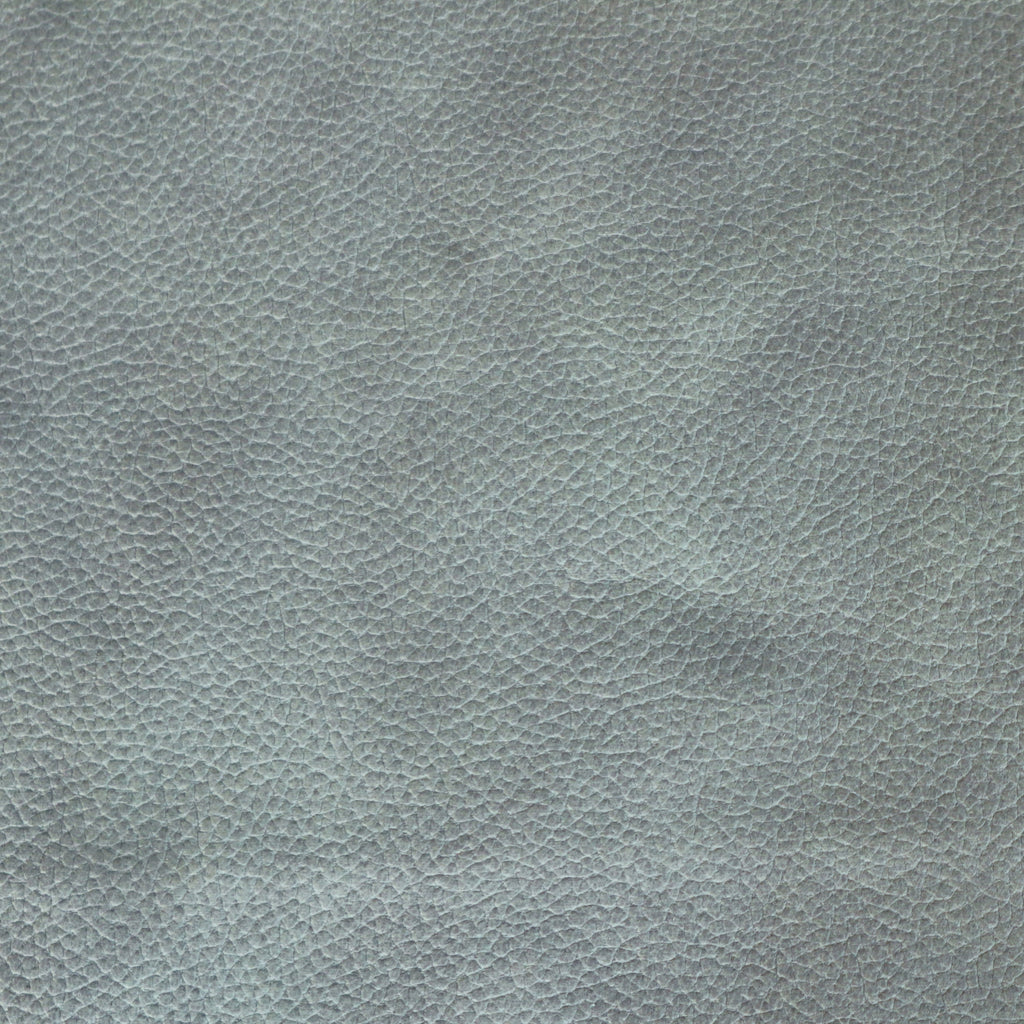 Close-up of blue faux leather upholstery showing a pebbled grain texture, suitable for a dining chair seat.