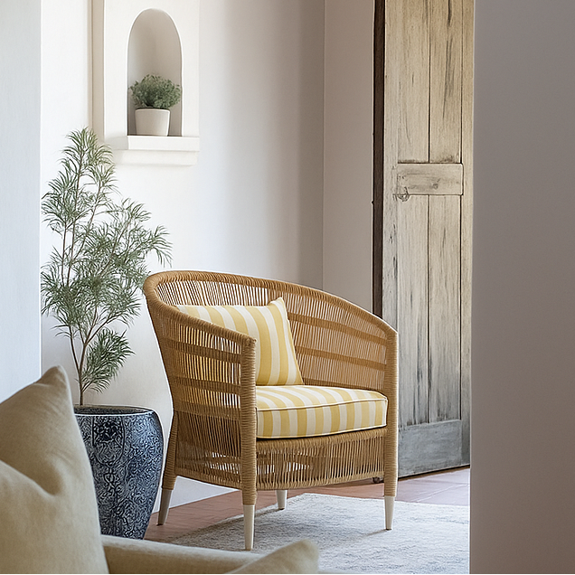 Sirena Wicker chair with yellow striped cushion in a room with a plant and wooden door. By nuema.com