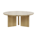 Modern round solid oak coffee table with a thick circular top and three-panel pedestal base in a light natural oak finish, shown against a white background.