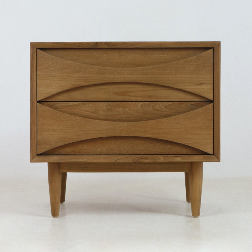 Natural teak two-drawer nightstand in mid-century Scandinavian style with carved recessed drawer pulls, tapered legs and warm wood grain finish shown on a pale neutral background.