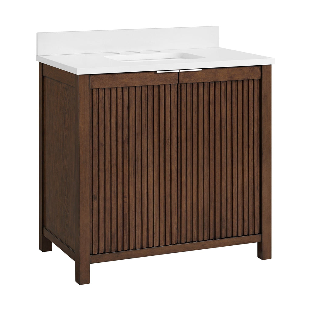 Freestanding solid wood single-sink bathroom vanity in warm brown with vertical fluted cabinet doors, white stone countertop with integrated rectangular sink, slim metal drawer pull and low backsplash.