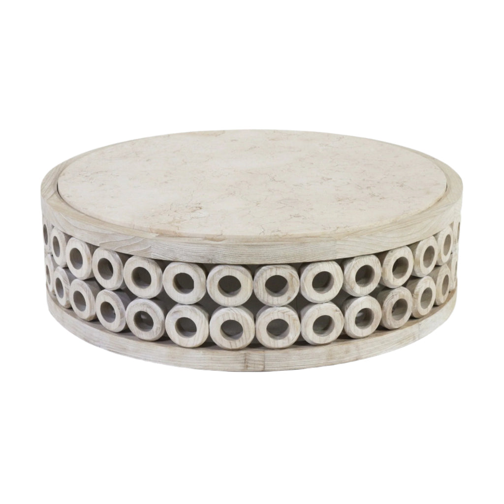 Round low-profile coffee table with a light travertine marble top and a natural oak base featuring two rows of hollow circular wooden cylinders for a sculptural, modern look.