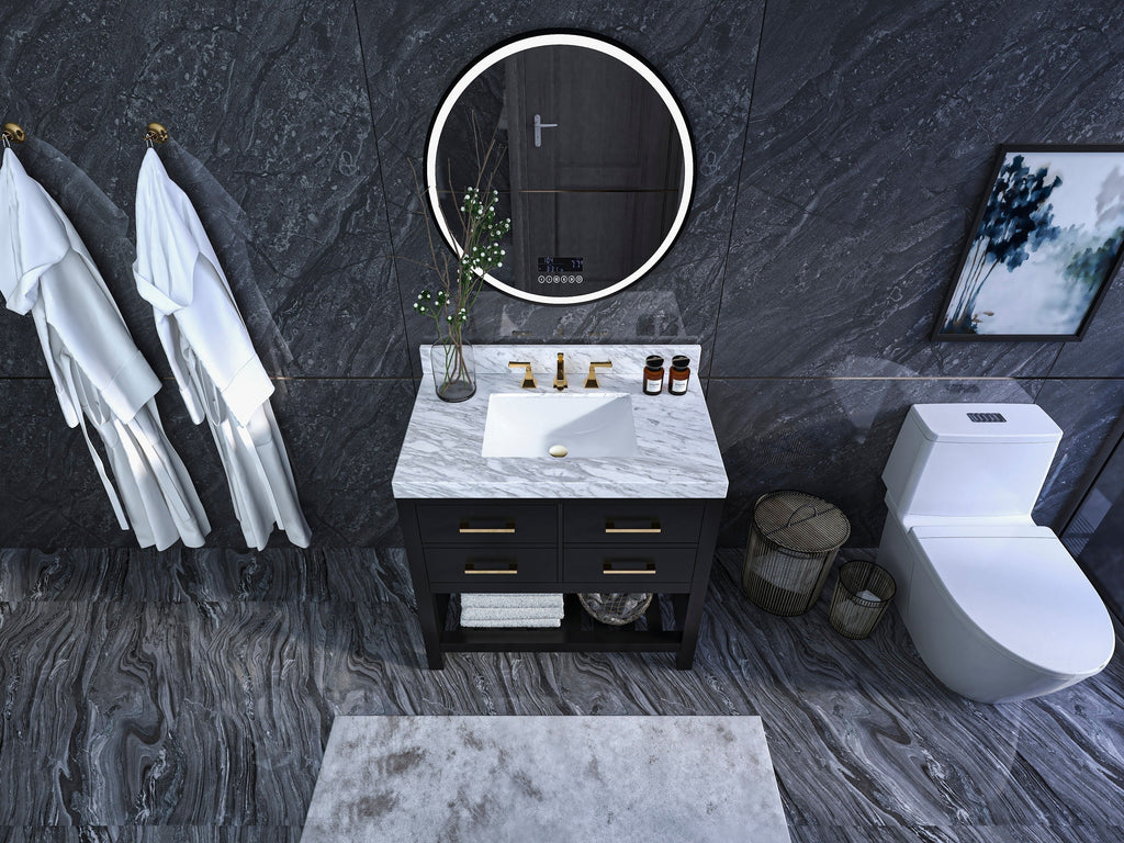 Modern 36-inch solid wood black single-sink vanity with a white rectangular undermount sink in a marble stone top, gold faucet and drawer pulls, open towel shelf, round illuminated mirror and dark stone walls and floor.