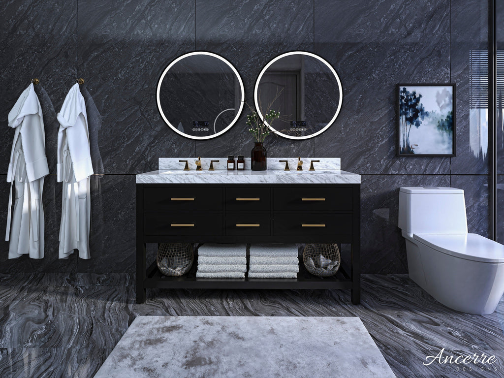 Modern 60-inch solid wood double-sink vanity with white stone marble top, black wooden base, brushed-gold hardware, two round backlit mirrors and open lower shelf with folded towels against dark stone walls.