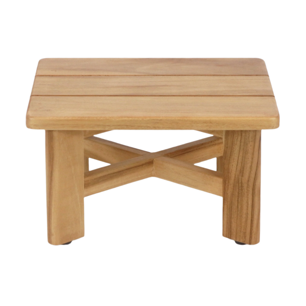 Mid-century modern low teak shower stool with a slatted rectangular top, cross-braced X stretcher and four short square legs in a natural teak finish, shown on a white background.