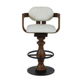 Front view of a light gray fabric-upholstered bar stool with curved wooden arms and oval cushioned back, turned natural wood pedestal, black metal circular footrest ring and round base in a counter-height swivel design.