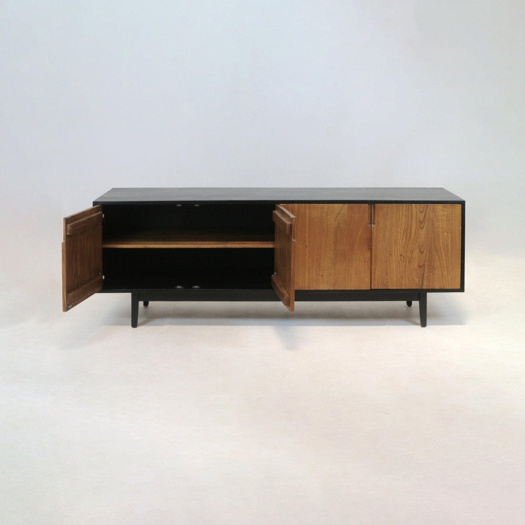 Long mid-century modern teak sideboard with a black frame and tapered legs, three teak doors (two open) revealing an internal shelf, photographed on a light studio background.